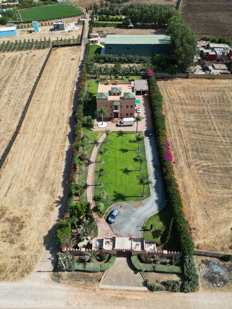 Vue drone d’une villa marocaine et de son jardin paysager avec palmiers — drone Marrakech