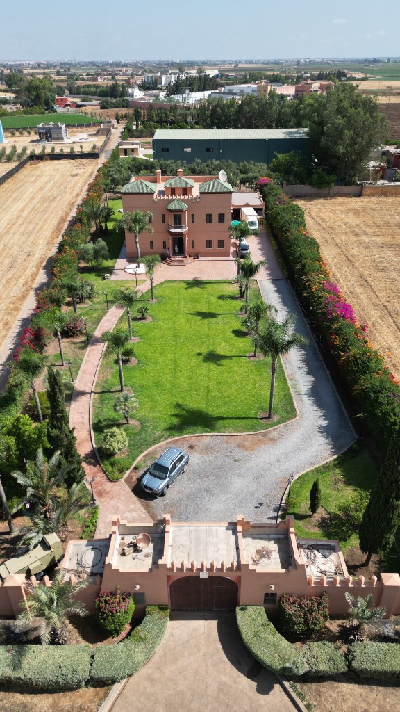 Vue plongeante sur villa de luxe, pelouse rectangulaire et haies fleuries — drone Marrakech