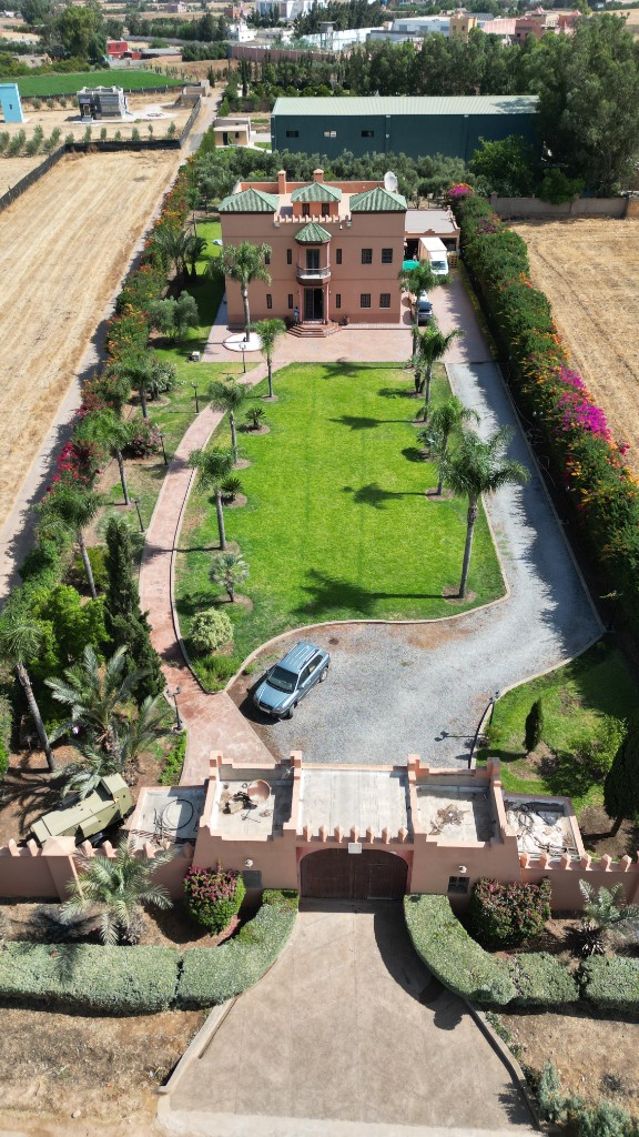 Plan aérien vertical d’un domaine villa, pelouse centrale et portail — drone Marrakech