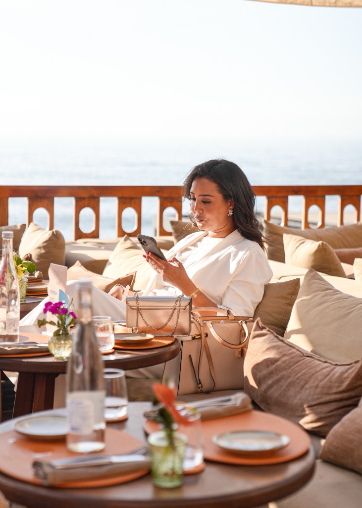 Portrait lifestyle d’une invitée en terrasse face à la mer — photographe événementiel Marrakech