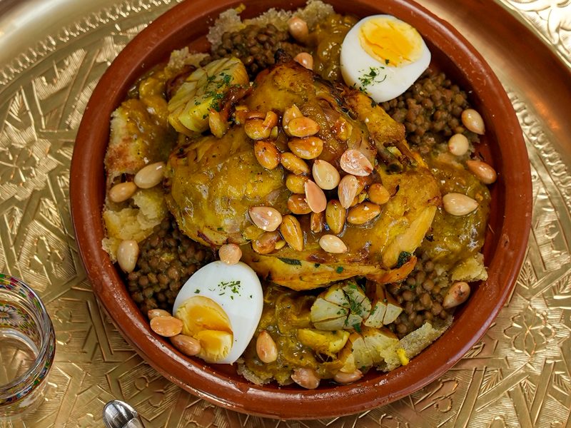 Photographe culinaire au Maroc — tajine de poulet aux amandes sur plateau doré