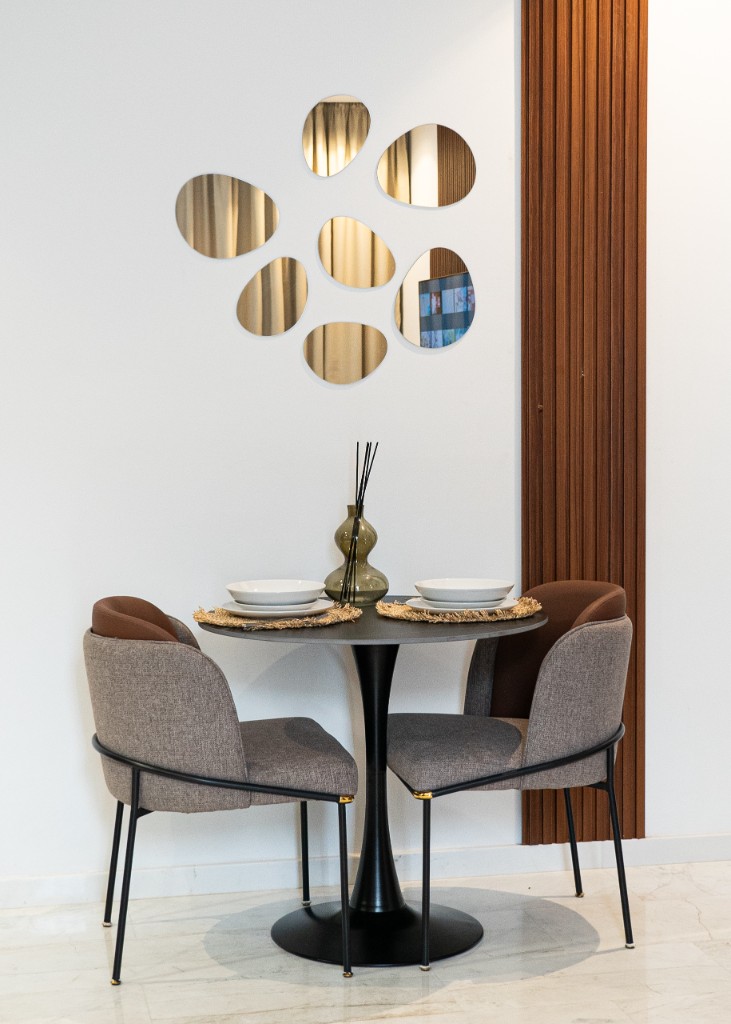 Coin repas moderne avec table ronde noire, chaises design et miroirs décoratifs — Marrakech