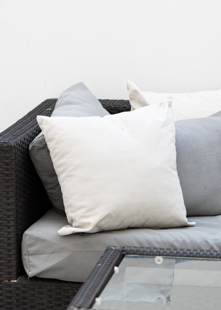 Détail d’un salon de jardin avec coussins et mobilier en rotin noir — Marrakech